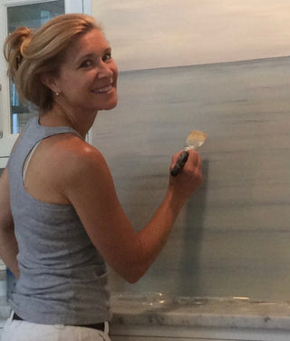 Caroline painting a still ocean work with the horizon and sky. 